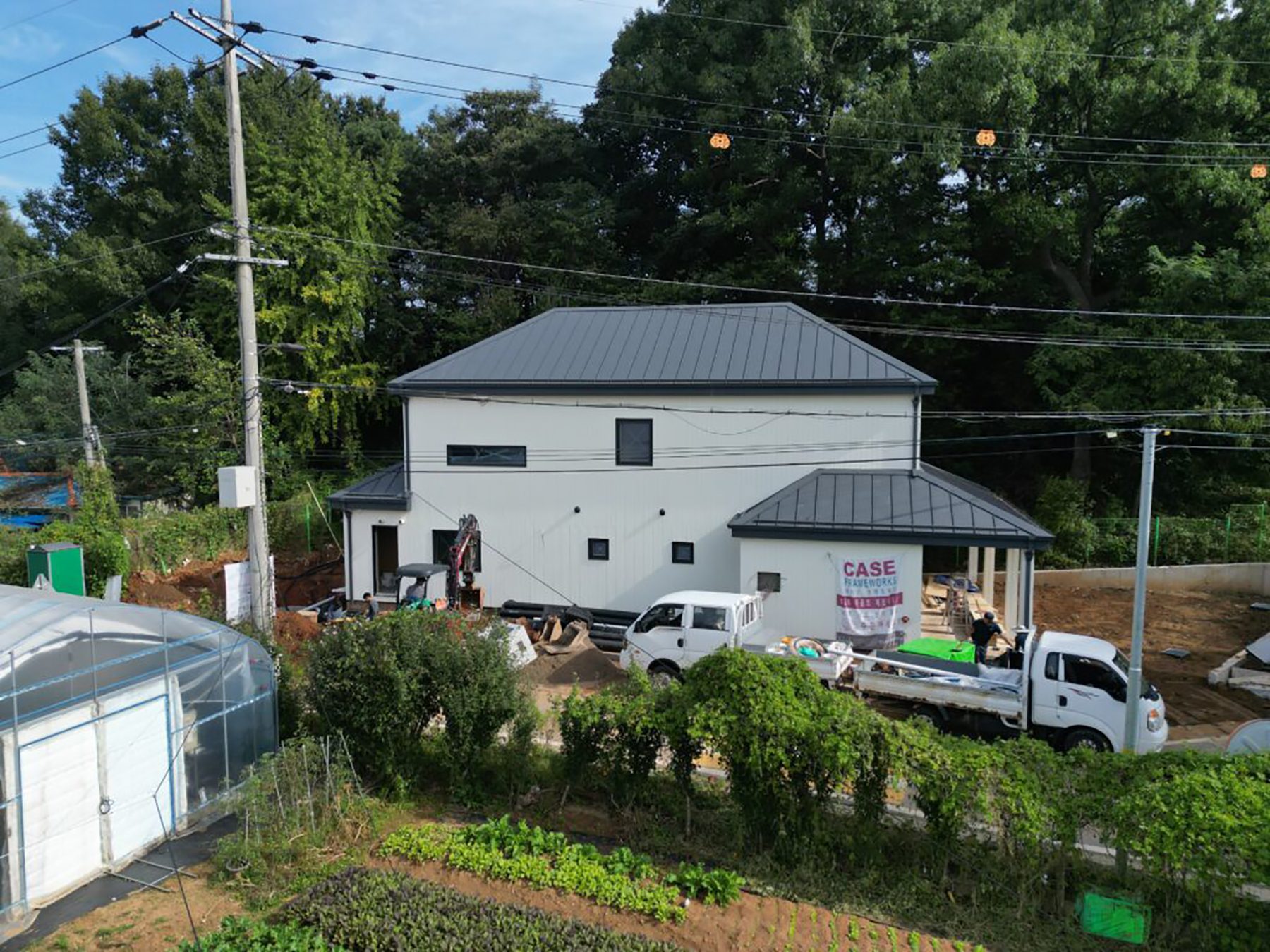 The finished home is shown with white walls and grey slanted roof.